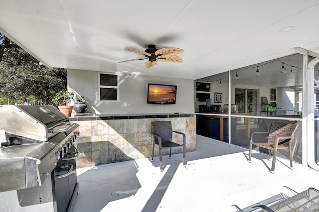 view of patio / terrace featuring ceiling fan, an outdoor kitchen, a grill, and outdoor wet bar