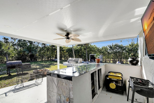 view of patio with outdoor wet bar, area for grilling, and a ceiling fan