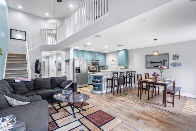 living room featuring light hardwood / wood-style flooring and a high ceiling