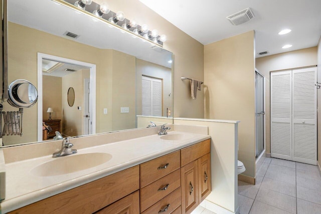 bathroom with vanity, a shower with door, tile patterned floors, and toilet