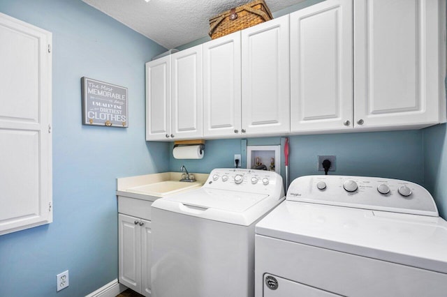 laundry area with independent washer and dryer, cabinets, sink, and a textured ceiling