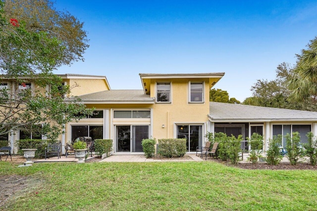 back of house with a sunroom, a patio area, and a lawn