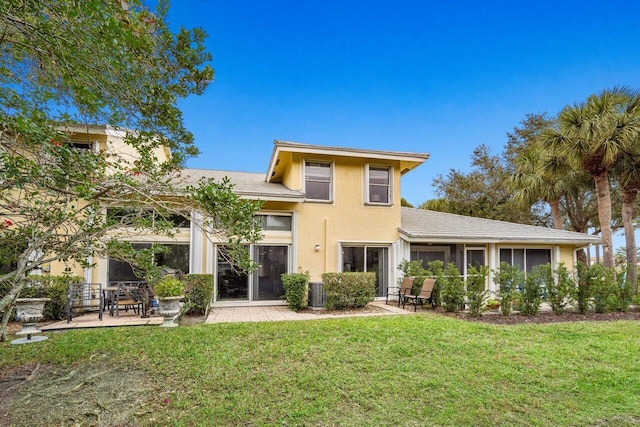 back of property featuring cooling unit, a yard, and a patio area