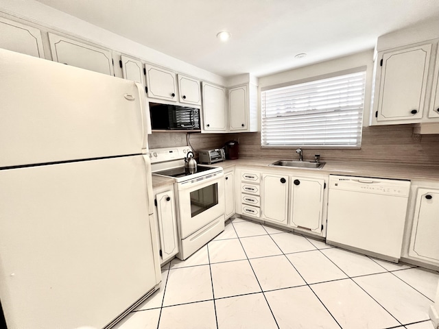 kitchen featuring sink, backsplash, white cabinets, and white appliances