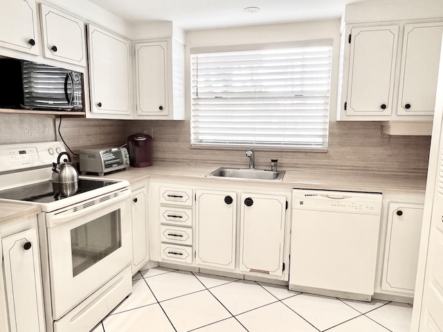 kitchen featuring white cabinetry, sink, light tile patterned flooring, and white appliances