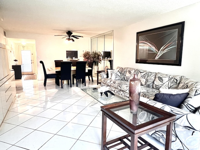 living room with ceiling fan and a textured ceiling