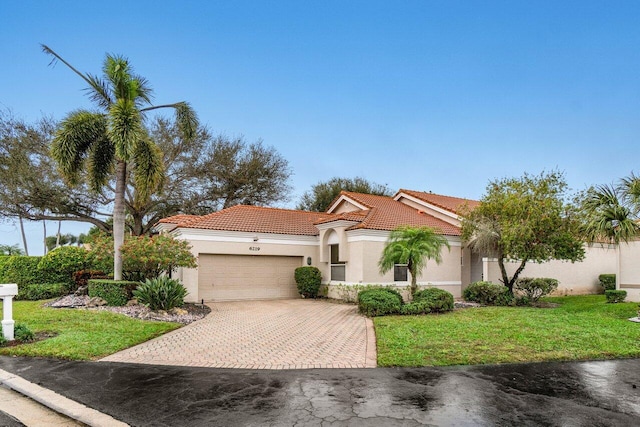 mediterranean / spanish-style house featuring a garage and a front lawn