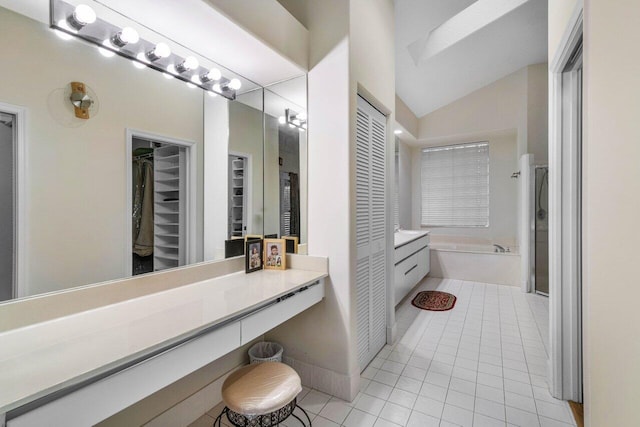 bathroom with lofted ceiling, tile patterned flooring, vanity, and tiled tub