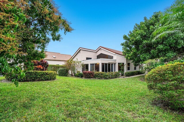 view of front of home with a front lawn and a sunroom