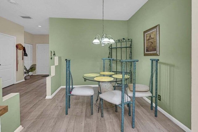 dining area featuring a notable chandelier and light wood-type flooring