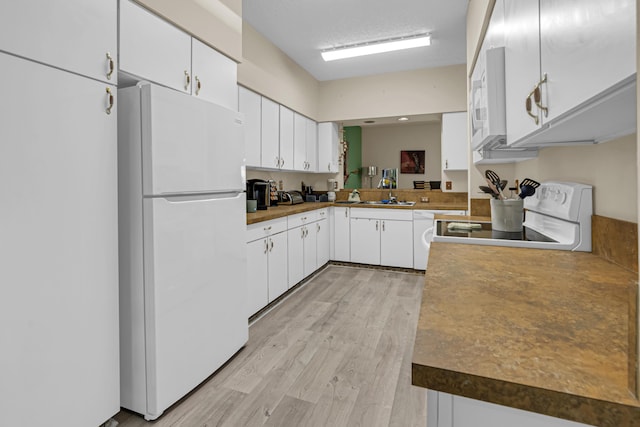 kitchen featuring white cabinetry, sink, white appliances, and light hardwood / wood-style flooring