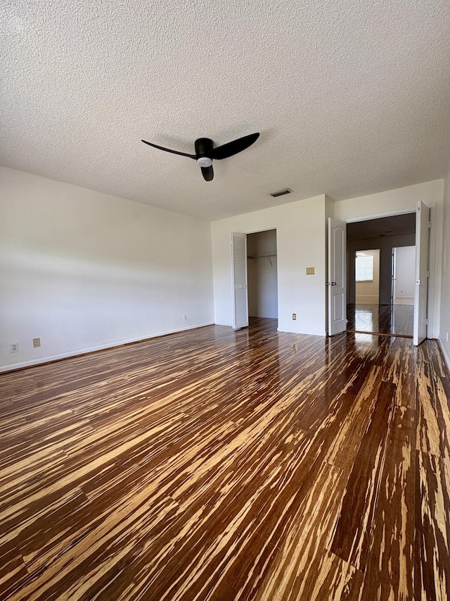 9189 Boca Gardens Cir Unit D, Boca Raton, FL 33496 - unfurnished living room featuring dark wood-style flooring, a textured ceiling, and ceiling fan