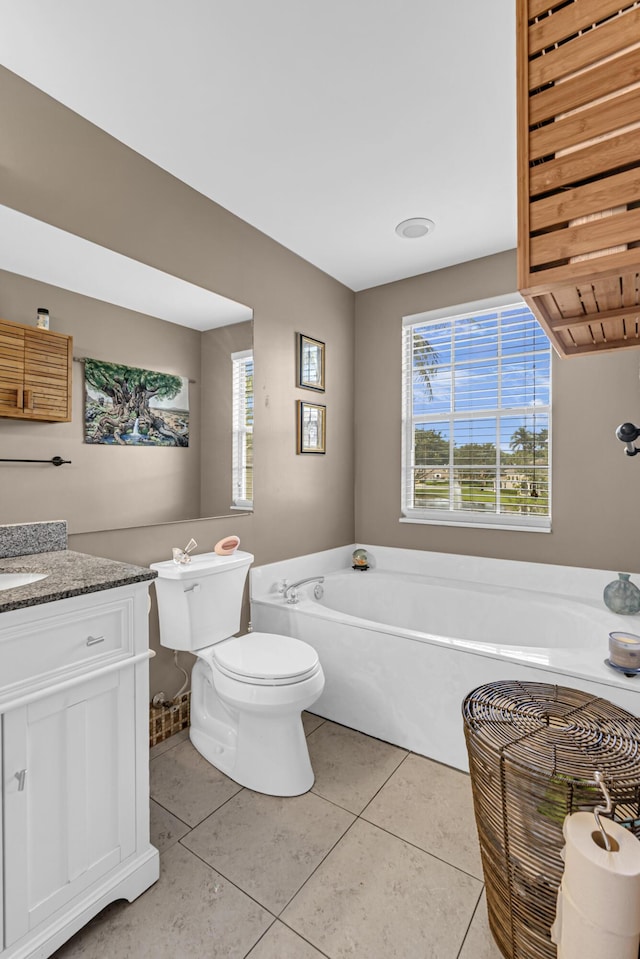 bathroom featuring vanity, tile patterned flooring, a bathing tub, and toilet