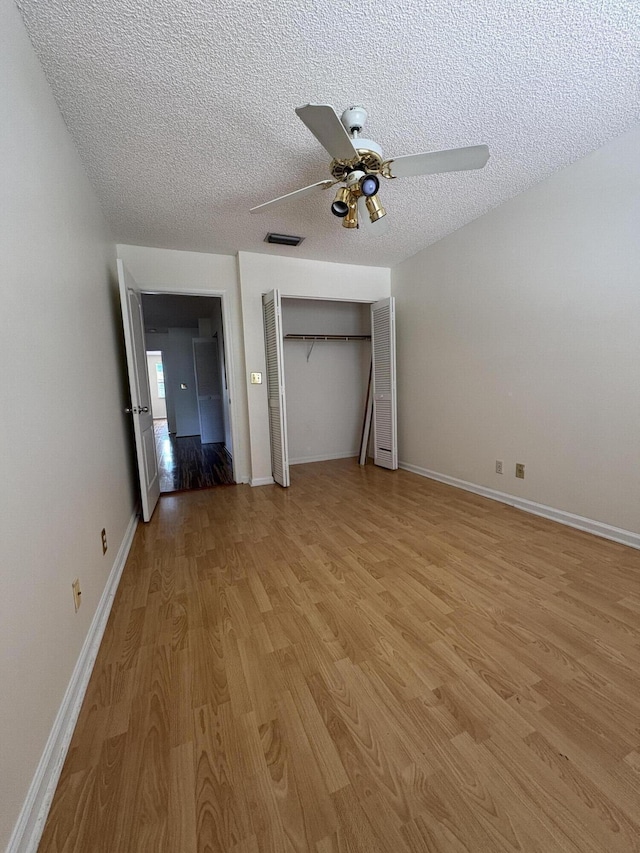 9189 Boca Gardens Cir Unit D, Boca Raton, FL 33496 - unfurnished bedroom featuring light wood-style floors, a textured ceiling, ceiling fan, and a closet