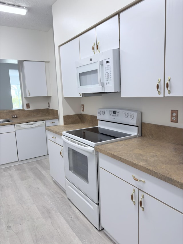 9189 Boca Gardens Cir Unit D, Boca Raton, FL 33496 - kitchen featuring white appliances, white cabinetry, and light wood-style flooring