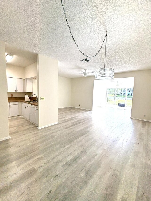 9189 Boca Gardens Cir Unit D, Boca Raton, FL 33496 - unfurnished living room featuring a textured ceiling and light wood-style floors
