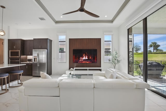 living room with ceiling fan and a tray ceiling