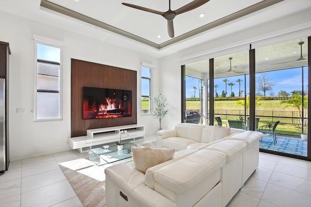 living room featuring a tray ceiling and ceiling fan