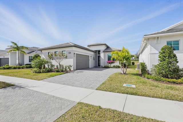 view of front of property featuring a garage, cooling unit, and a front lawn