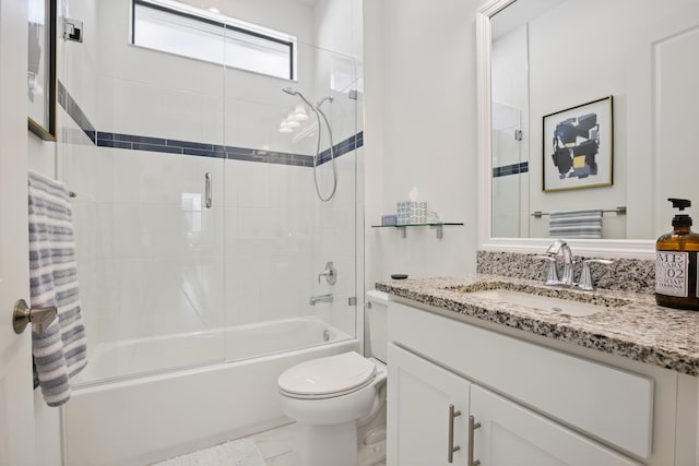 full bathroom featuring vanity, shower / bath combination with glass door, and toilet