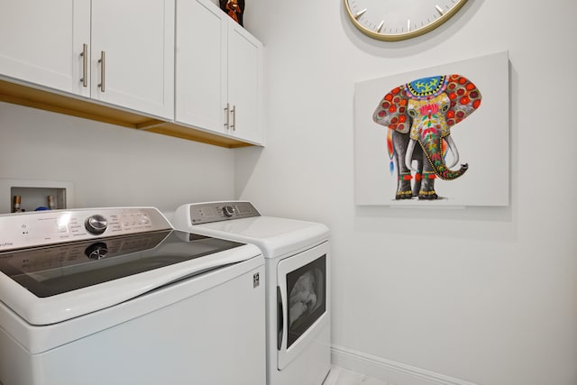 laundry area with cabinets and washer and clothes dryer