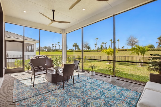 sunroom with a rural view, plenty of natural light, and ceiling fan