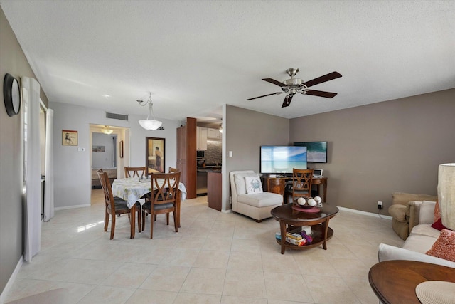 tiled living room featuring ceiling fan and a textured ceiling