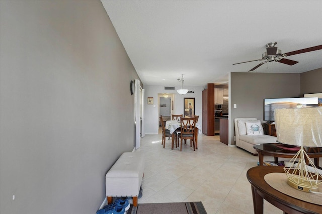 living room featuring light tile patterned floors and ceiling fan