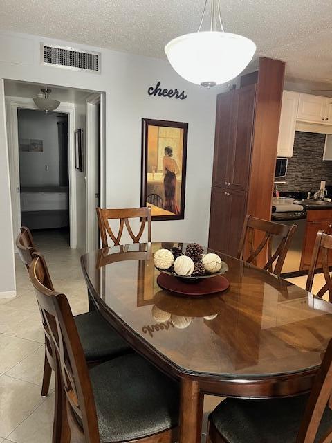 kitchen with washer / dryer, sink, a textured ceiling, light tile patterned floors, and stainless steel appliances