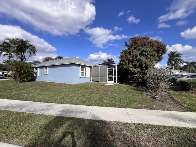 view of front of property with a front yard and glass enclosure