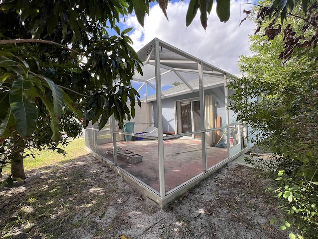 back of house with a lanai and a patio area