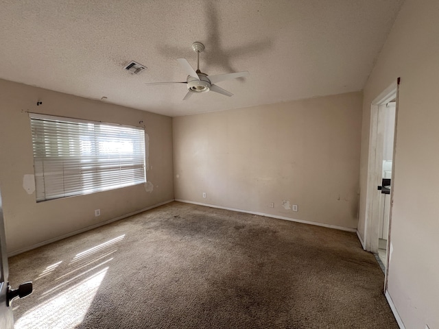 carpeted spare room with ceiling fan and a textured ceiling