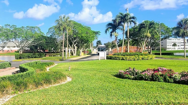 view of home's community featuring a lawn and a water view