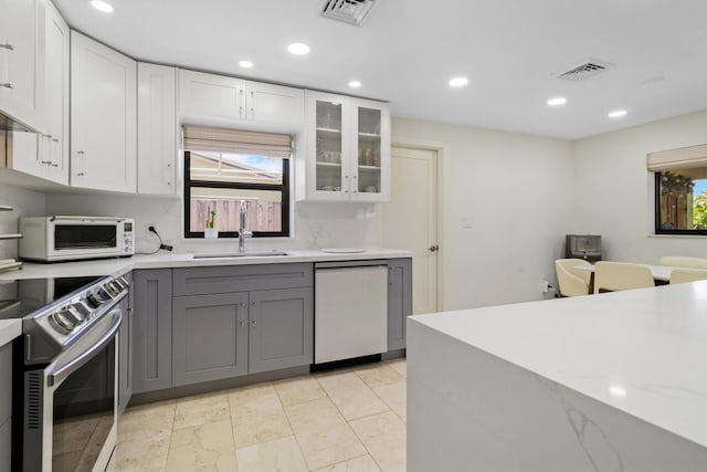 kitchen featuring white cabinetry, dishwasher, gray cabinets, and electric range