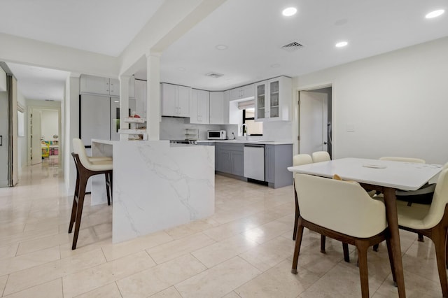 kitchen featuring gray cabinets, stainless steel dishwasher, and a kitchen island