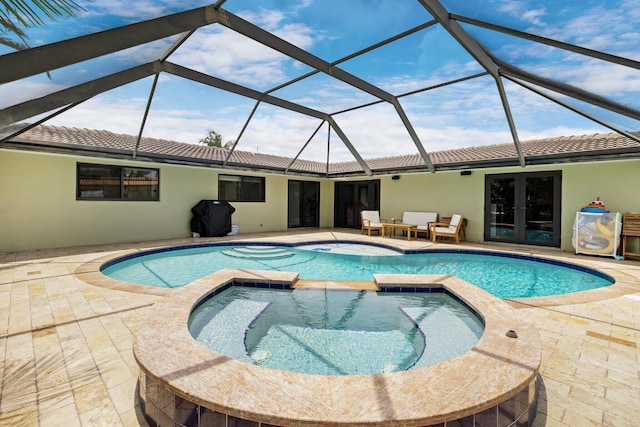 view of swimming pool with an in ground hot tub, a lanai, a patio area, and french doors