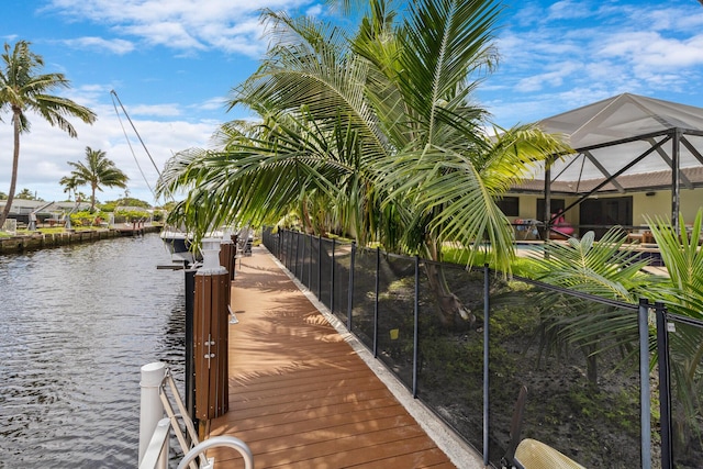 view of dock with a water view and glass enclosure