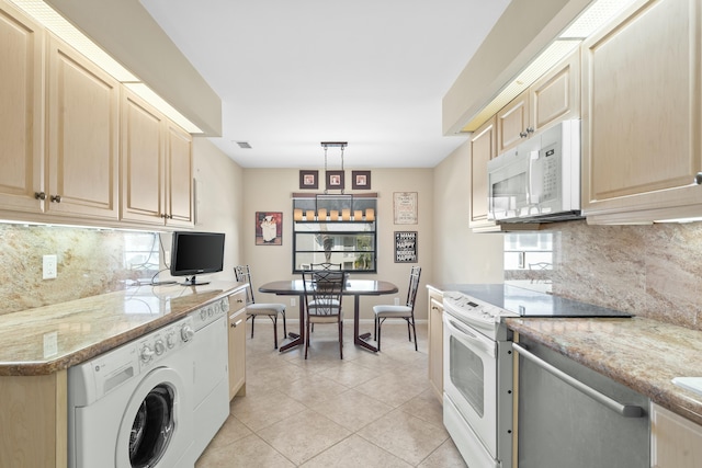 kitchen with white appliances, hanging light fixtures, light tile patterned flooring, washer / clothes dryer, and decorative backsplash