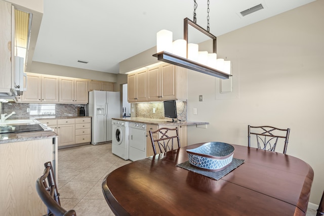 tiled dining room featuring sink and washer and clothes dryer