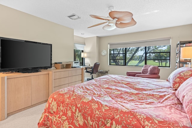 carpeted bedroom featuring ceiling fan and a textured ceiling