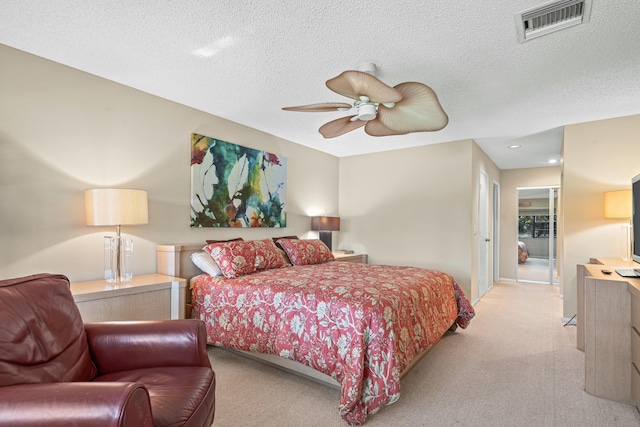 carpeted bedroom with ceiling fan and a textured ceiling