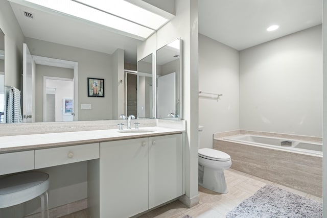 bathroom featuring a relaxing tiled tub, vanity, and toilet