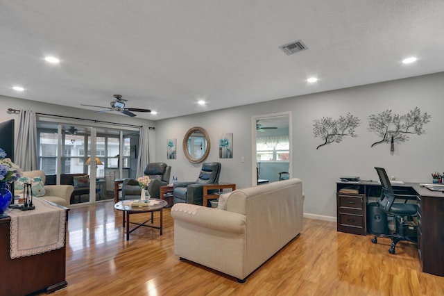 living room with ceiling fan and light wood-type flooring