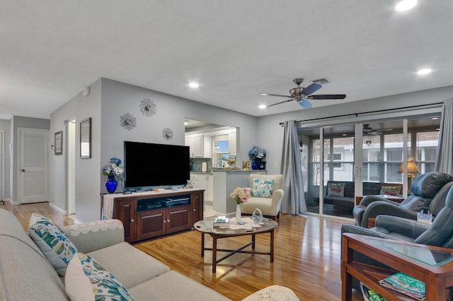 living room with ceiling fan and light wood-type flooring