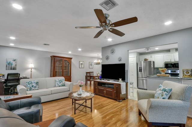 living room with ceiling fan and light hardwood / wood-style flooring