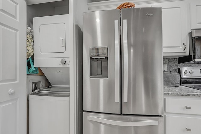 laundry area with stacked washer / drying machine