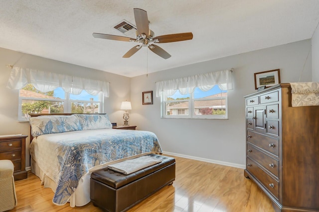 bedroom featuring multiple windows, light wood-type flooring, and ceiling fan