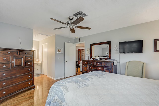 bedroom with light hardwood / wood-style flooring, ceiling fan, and ensuite bath