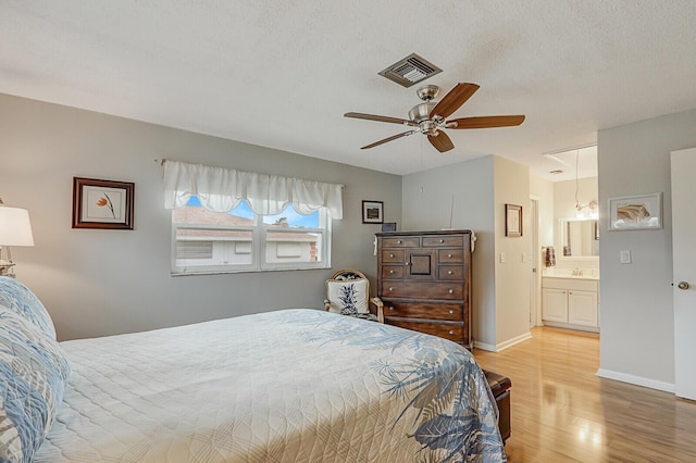 bedroom with connected bathroom, sink, ceiling fan, a textured ceiling, and light hardwood / wood-style flooring