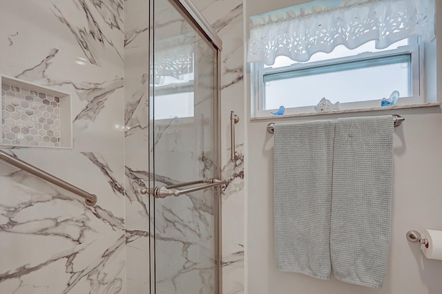 bathroom featuring a shower with door